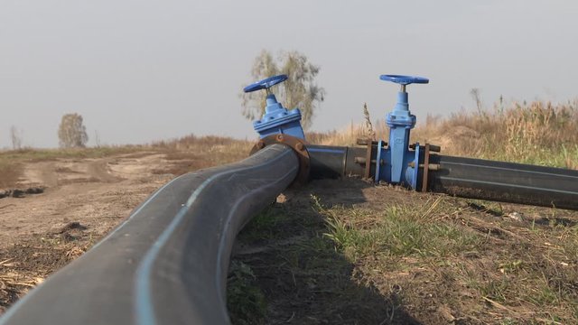 Environmental problem. Cleaning the bottom of the reservoir from non-consolidated silt sediments. Sand mining. Blue butterfly valve on floor and PE. black pipe for raw water pump