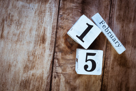 February 15th. Day 15 of February month, white calendar blocks on vintage wooden table background. Winter time. Empty space for text.