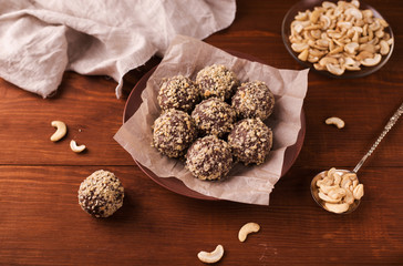 Cocoa balls, chocolate truffles cakes on board on wooden background