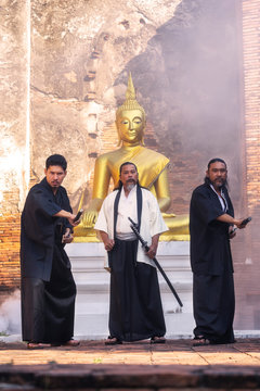 Samurai warrior standing with a sword in front of Buddha.