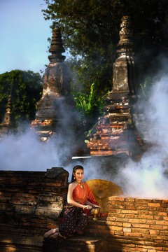 Thai woman wearing period tradition clothes style toothy smiling face and Sitting and waiting to offer food to the monks