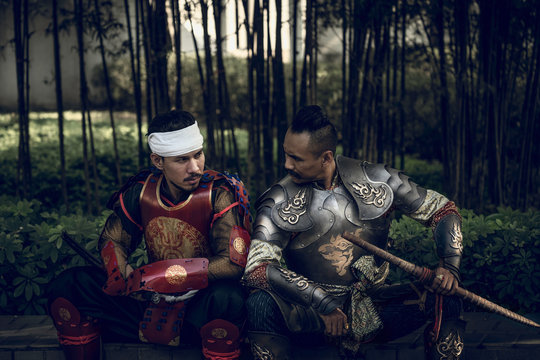 A samurai warrior sitting face to face with a Thai warrior in the Ayutthaya period. Wearing a warrior's suit, protected by a sword