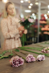Florist makes a bouquet. Working florist in a flower shop. Woman making fashion modern bouquet of different flowers. Women working with flowers in workshop