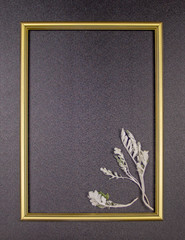 Decorative composition, golden photo frame on a gray background with leaves. Flat lay, top view, copy space.