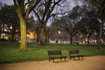 Two empty wood benches in park at twilight 