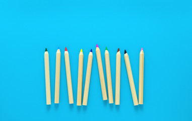 Colorful wooden pencils on blue background. Copy space. Top view. School stationery.