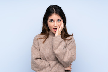 Young brunette woman wearing a sweater over isolated blue background surprised and shocked while looking right