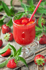 Strawberry smoothie in  glass with mint leaves on wooden   background