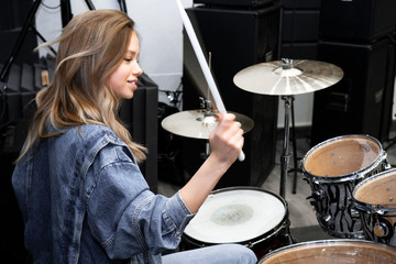 Creativity and music. Young beautiful girl plays the drums. Recording Studio. Musical equipment.