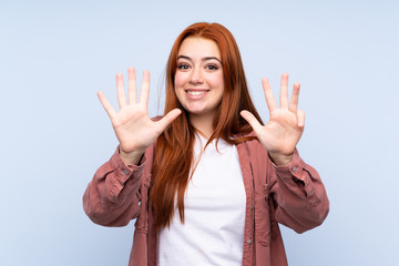 Redhead teenager girl over isolated blue background counting nine with fingers