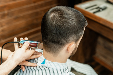 Haircut at the hairdresser. Barber cuts the hair on the client's head. The process of creating...