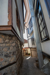 The architecture of the old town. Narrow cobblestone street between picturesque Revival houses. Ohrid, Northern Macedonia.