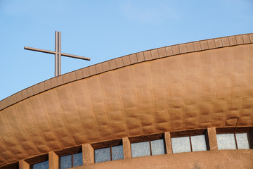 Fototapeta premium Round Church building with a cross in the rays of the setting sun against the blue sky.