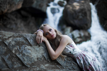 Girl on the background of a waterfall