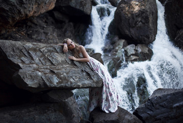 Girl on the background of a waterfall