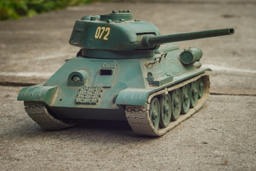 Scale model tank on a concrete background. Toy. Background.