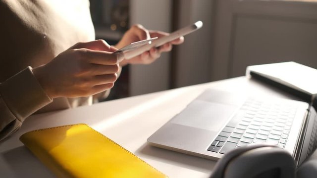 Female hand holding credit card and shopping online. Easy pay using digital gadget. Girl using laptop at home. Happy woman with compact computer and bank card shopping online. Lifestyle.