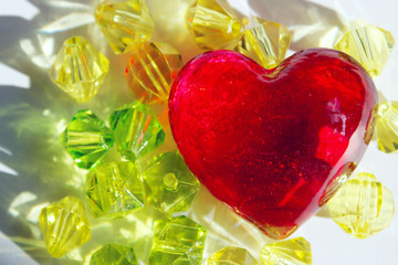  Blurry image of red glass heart and yellow beads. Abstract love background. Hand made, Valentine day, objects concept. - Powered by Adobe