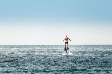 Man participates in extreme sea sport attraction. Water board with a jet flow