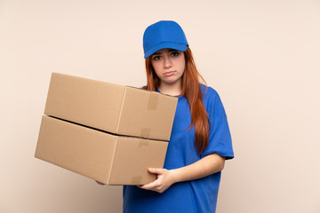 Young teenager delivery girl over isolated background pleading