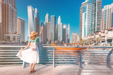 Abwaschbare Fototapete Dubai Fröhliches asiatisches Reisendesmädchen, das auf einer Promenade im Dubai Marina-Viertel geht. Reiseziele und touristischer Lebensstil in den Vereinigten Arabischen Emiraten