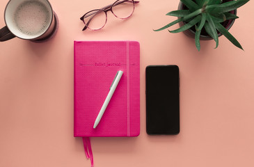 Stock photo of a notebook with pencil and mobile phone on a pink background - Powered by Adobe