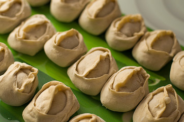 Traditional meat dish of the peoples of Central Asia. National cuisine. Russian cuisine. Minced meat wrapped in a thin dough. Handmade. Traditional Turkish Manti with yoghurt and Vinegar.