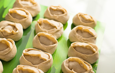 Traditional meat dish of the peoples of Central Asia. National cuisine. Russian cuisine. Minced meat wrapped in a thin dough. Handmade. Traditional Turkish Manti with yoghurt and Vinegar.