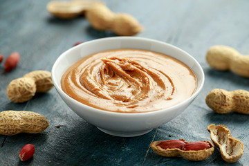 Smooth Peanut Butter in white bowl with nuts