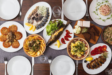 large wooden table with mouthwatering national Russian dishes. The restaurant where the food is cooked is as satisfying and delicious as home, top view