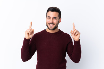 Young handsome man with beard over isolated white background pointing up a great idea