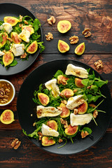 Vegetarian camembert cheese, fig and Arugula, hot rocket salad served on black plate