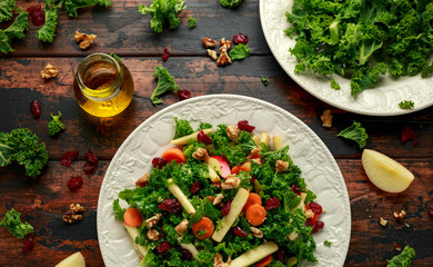 Kale salad with dried cranberry, carrots, walnuts and apple. healthy vegan food.