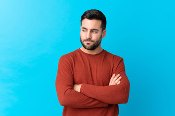 Young handsome man with beard over isolated blue background thinking an idea