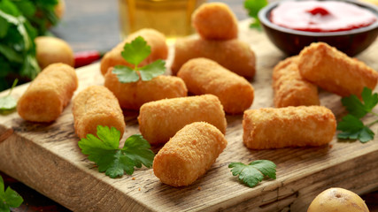 Homemade Potato Croquettes with dipping sauce on wooden board