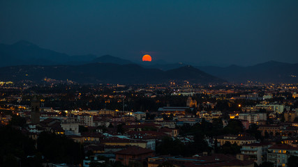 Red moon rises over Bergamo city, Italy