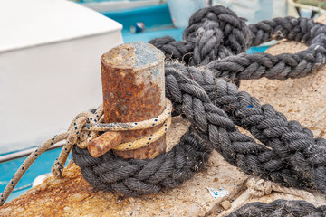 Fototapeta na wymiar Rope on biteng against the background of water in the port.