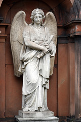 Obraz premium A weathered, white sandstone sculpture of a grieving angel with spread wings in front of an old crypt of an cemetery in Berlin-Germany.