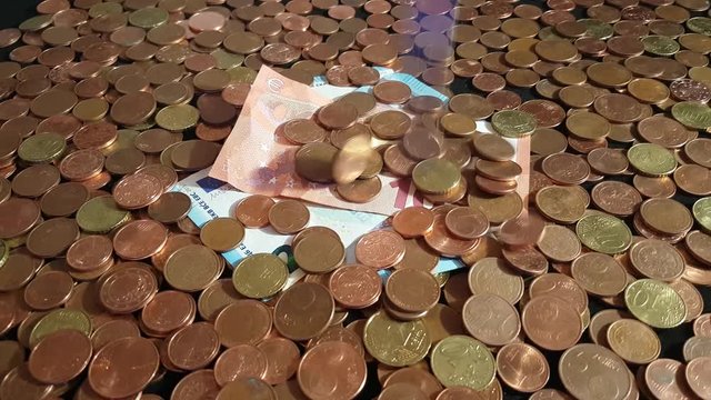 Euro cent coins falling on euro bills and burying them and building up to a pile, concept of EU planning to phase out cent coins