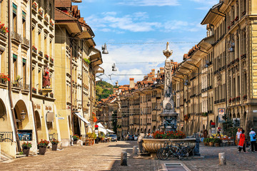 Bern, Switzerland - August 31, 2016: People at Kreuzgassbrunnen in Kramgasse street with shopping area in old city center of Bern, Switzerland - obrazy, fototapety, plakaty