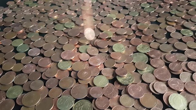 Euro cent coins falling and building a pile, concept of EU planning to phase out euro cent coins