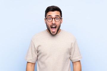 Fototapeta premium Young handsome man with beard over isolated blue background with surprise facial expression