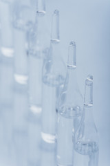 Glass medical ampoule vial for injection. Medicine is dry white drug penicillin powder or liquid with of aqueous solution in ampulla. Close up.