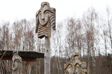 wooden images on poles in the field and forest