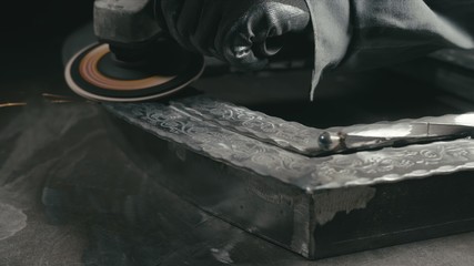 Forge workshop. Smithy manual production. Polish metal with an angle grinder with an abrasive...