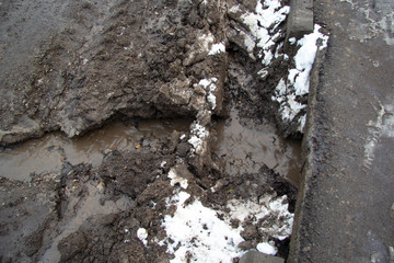 Melty dirty water flows in a stream along the road