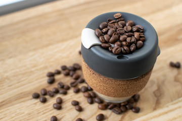 Reusable Coffee Eco Cup. Toughened Glass Cup & Natural Cork Band. Secure silicon lid. Reusable eco cup on a wooden background.Eco-Friendly, Spill Proof Travel Mug with Lid | Black. Keep Cup