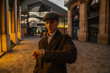 Old Fashion Man from the 1920s england walking along an old street of a historic city. He is...