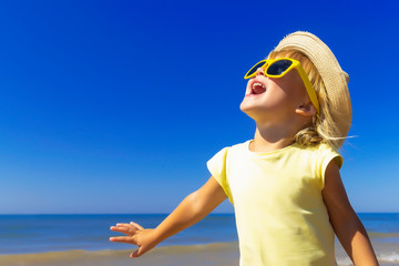 Fototapeta na wymiar Happy child enjoying to the sun at the beach