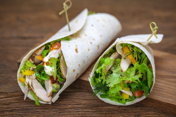 meat pita bread with vegetables with avocado, tortillas stuffed with meat and vegetables on wooden background.
